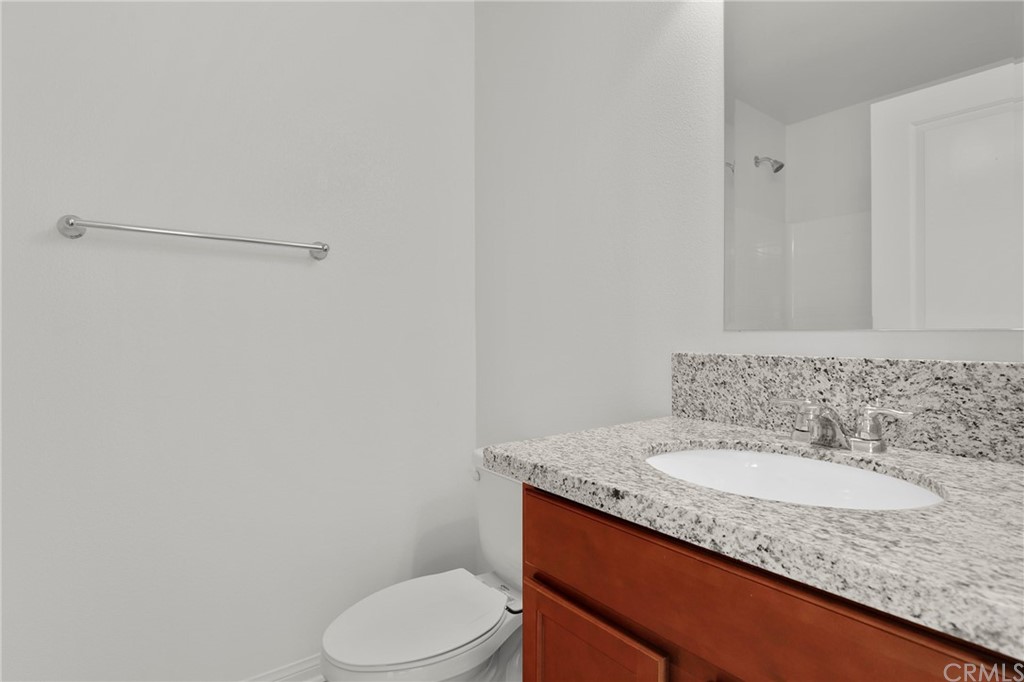 29309 First Green Lake Elsinore, CA 92530 - Photo 33 of 59 a bathroom with a granite countertop sink and a toilet