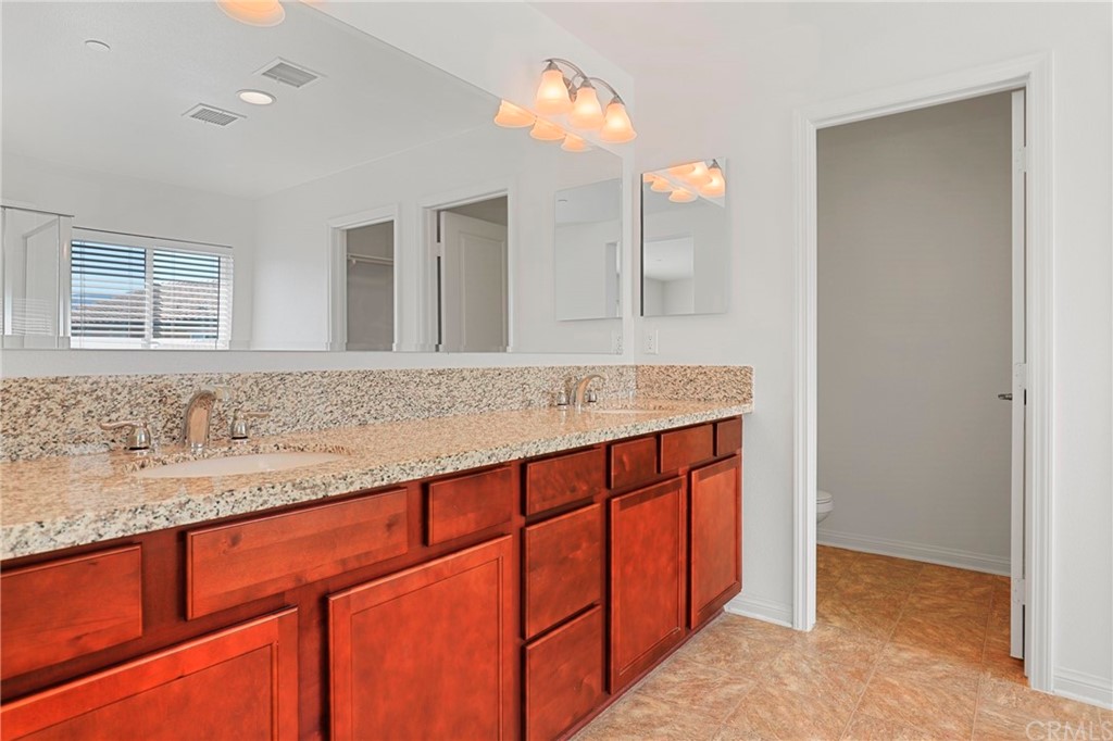 29309 First Green Lake Elsinore, CA 92530 - Photo 41 of 59 a bathroom with a granite countertop sink and a mirror