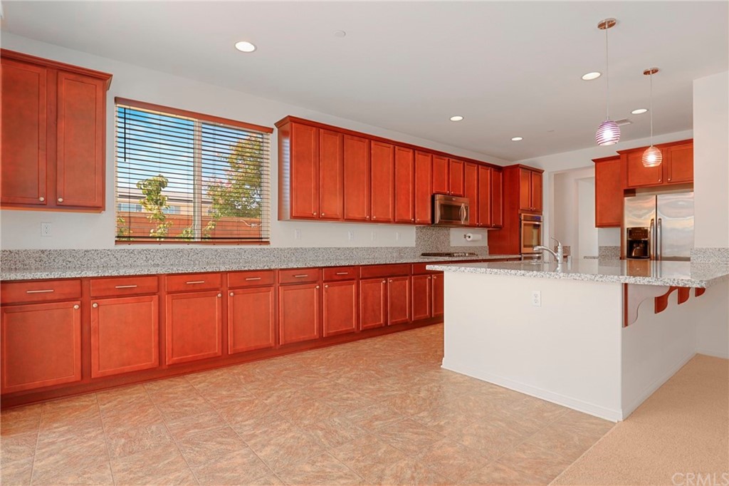 29309 First Green Lake Elsinore, CA 92530 - Photo 9 of 59 a kitchen with stainless steel appliances granite countertop a stove a sink a refrigerator a sink and dishwasher with wooden cabinets