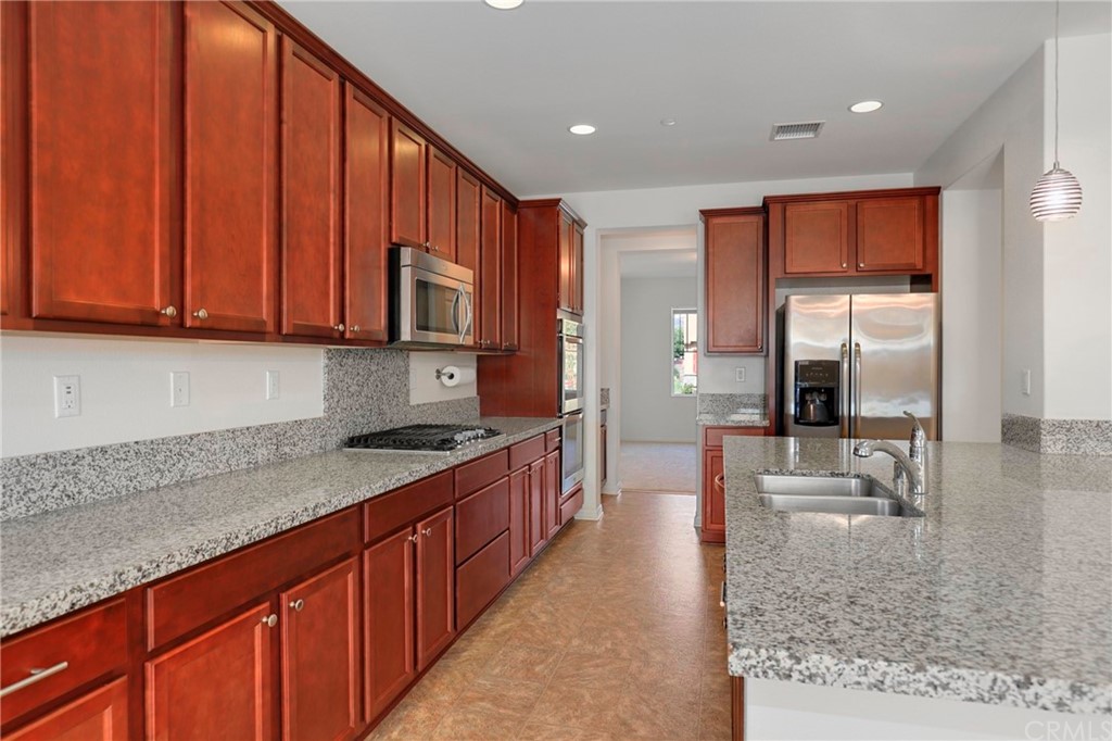 29309 First Green Lake Elsinore, CA 92530 - Photo 10 of 59 a kitchen with stainless steel appliances granite countertop wooden cabinets a sink and dishwasher