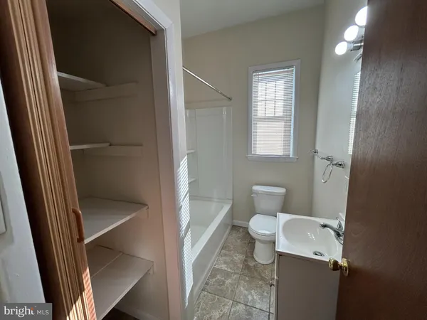 a bathroom with a tub a sink and a large mirror