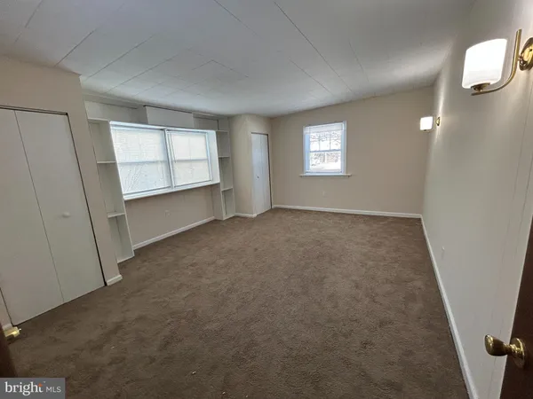 an empty room with windows and closet
