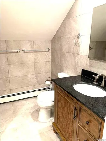 a bathroom with a granite countertop sink a toilet a mirror and shower