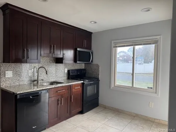 a kitchen with stainless steel appliances granite countertop a sink stove and microwave