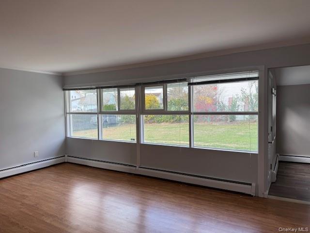 154 Kingfisher Road Levittown, NY 11756 - Photo 5 of 20 an empty room with wooden floor and windows