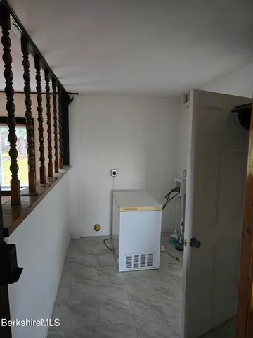 an empty room with wooden floor a fireplace and windows