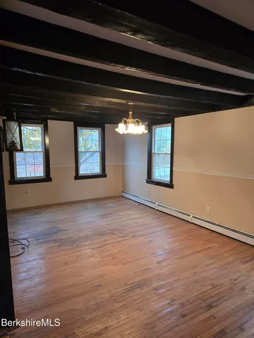 a view of a house with a large tree and a yard