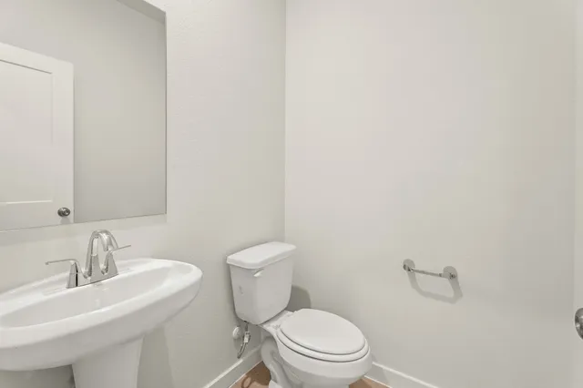 a white toilet sitting next to a bathroom sink