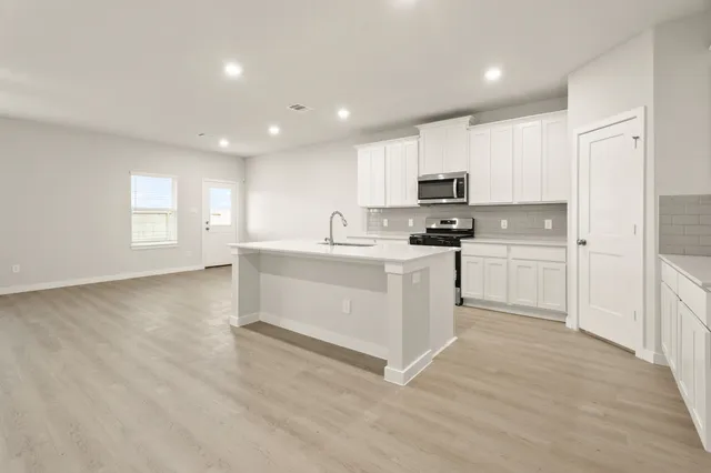 a kitchen with white cabinets and white appliances