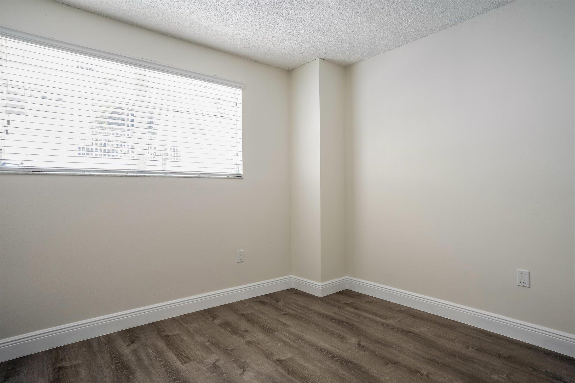 1673 Bay Road, Unit 206 Miami Beach, FL 33139 - Photo 12 of 19 an empty room with wooden floor and windows