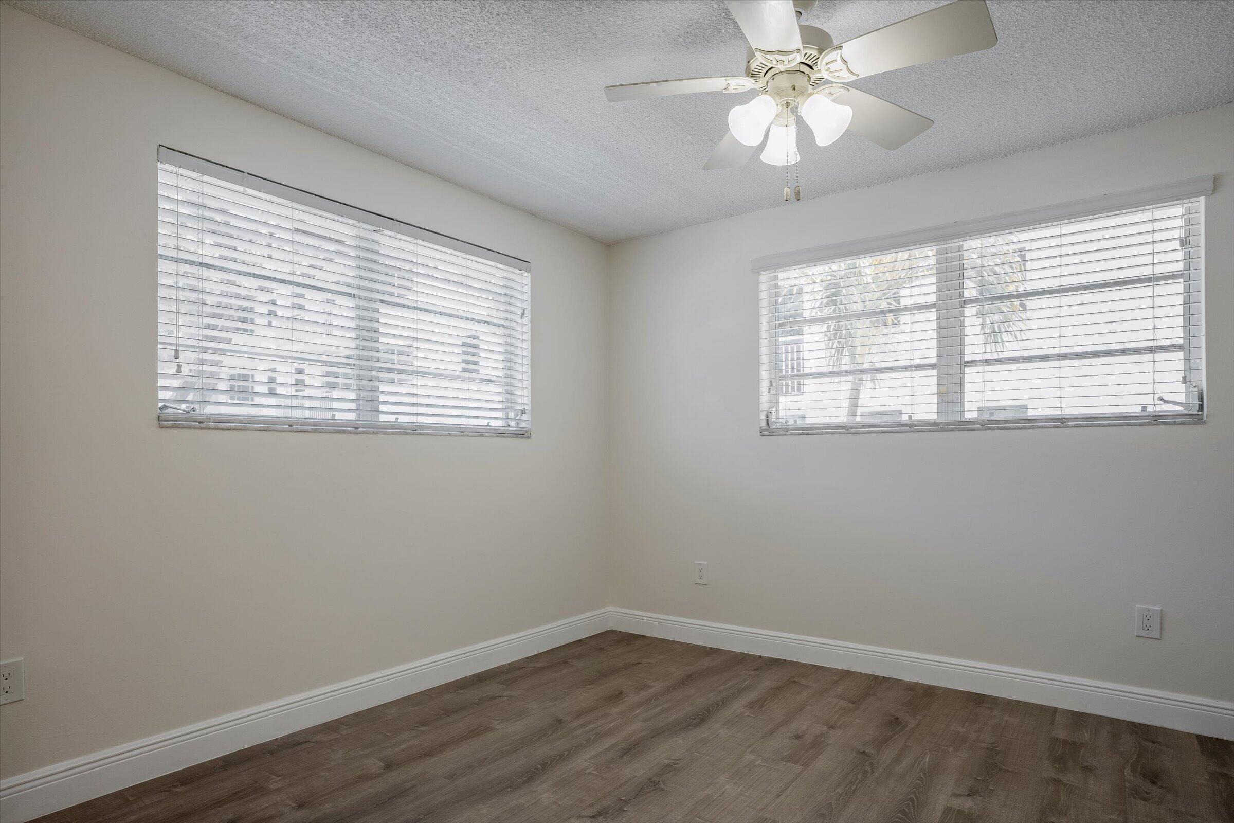 1673 Bay Road, Unit 206 Miami Beach, FL 33139 - Photo 15 of 19 a view of an empty room with a window and wooden floor