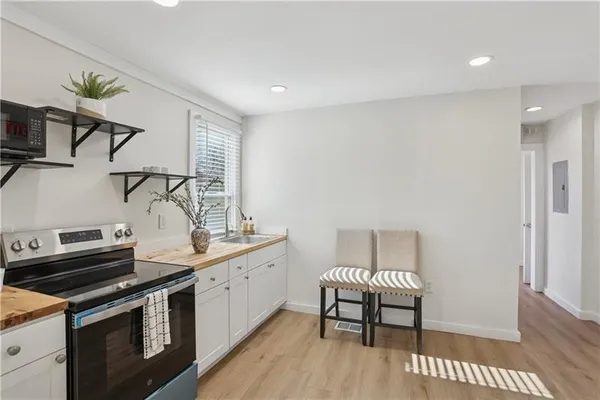 a kitchen with a stove and a wooden floor