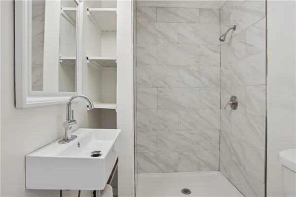 a bathroom with a sink a shower and a mirror