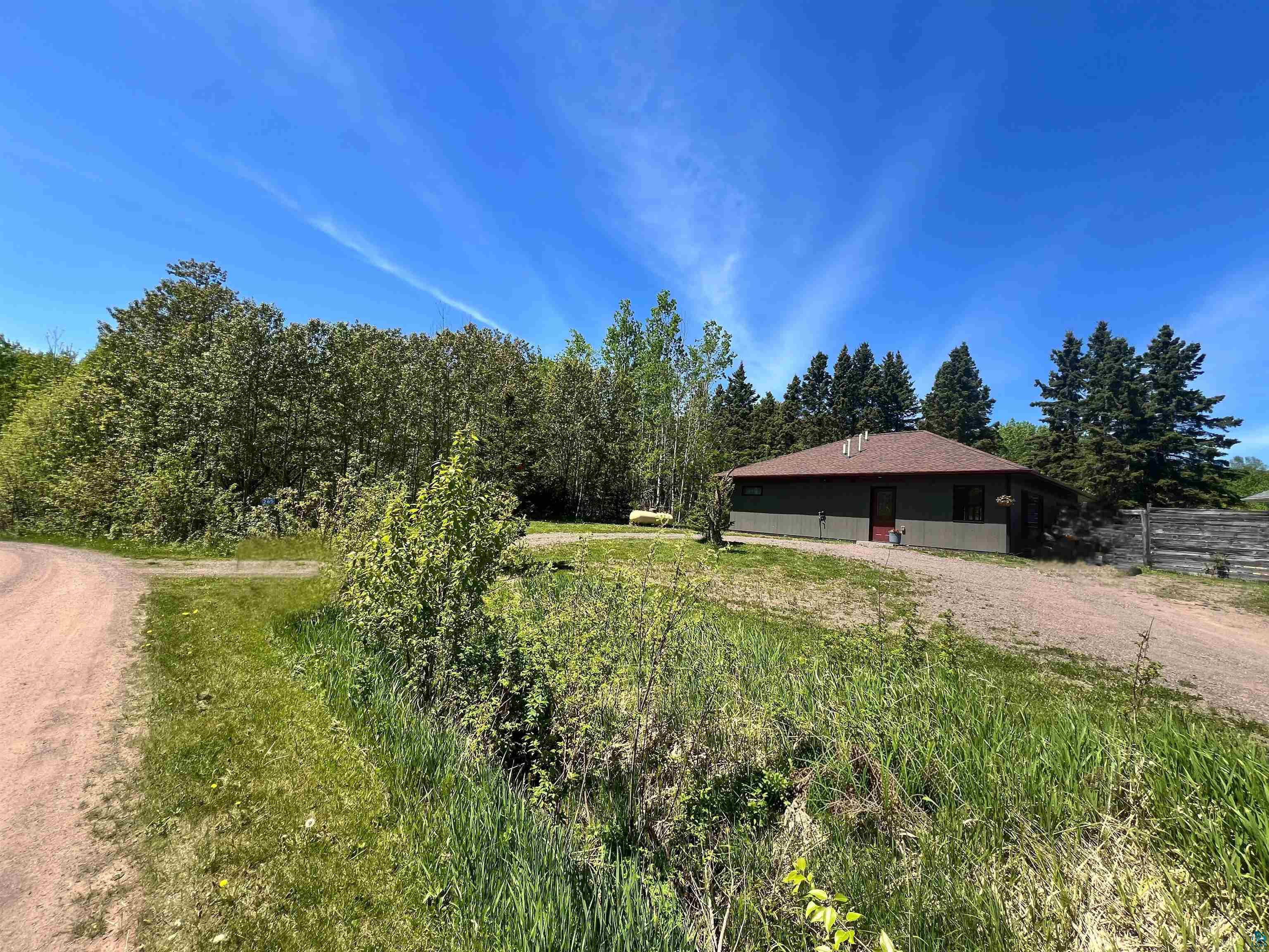 265 Mink Ranch Road Lutsen, MN 55612 - Photo 2 of 32 Single-story residence with a red-shingled roof and dark green siding
