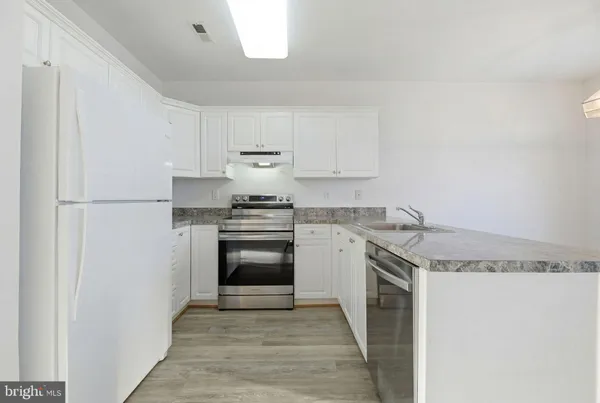 a kitchen with granite countertop stainless steel appliances and wooden cabinets