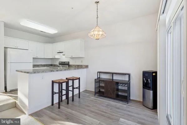 a kitchen with stainless steel appliances granite countertop a stove a refrigerator and a fireplace with wooden floor