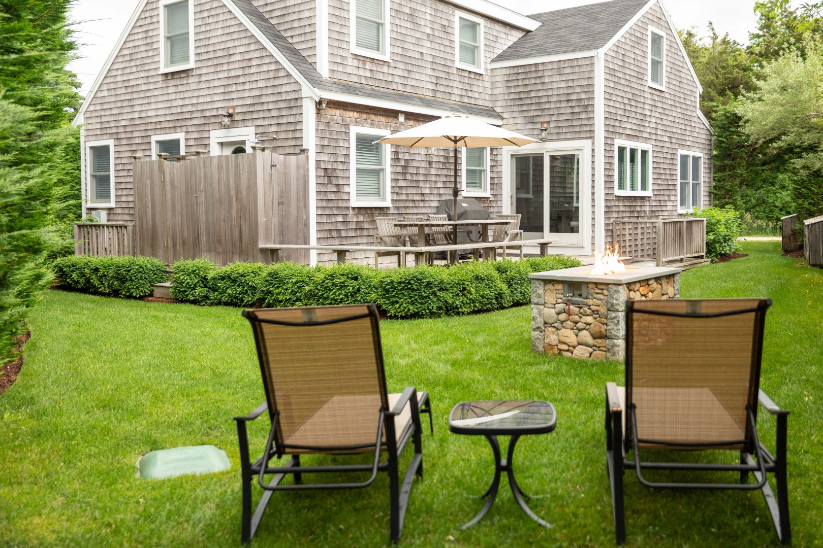 10 Pilgrim Road Nantucket, MA 02554 - Photo 2 of 65 a view of a chair and table in backyard of the house