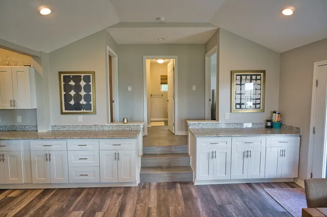 a kitchen with stainless steel appliances granite countertop a sink and a refrigerator