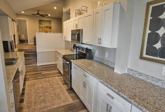 a kitchen with white cabinets and refrigerator