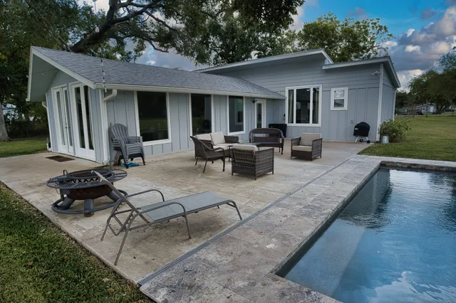 a view of a house with backyard sitting area and garden
