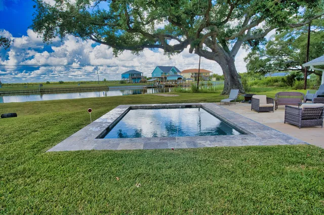 a view of yard with swimming pool and green space