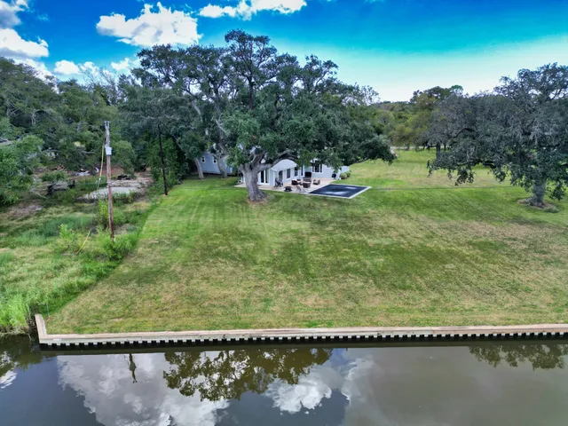 an aerial view of residential houses with outdoor space and river