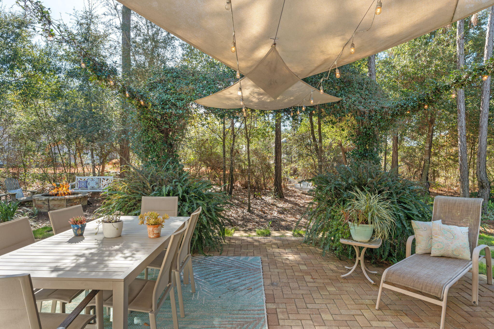 78 Grizzly Street Freeport, FL 32439 - Photo 41 of 65 a patio table and chairs with potted plants and large tree