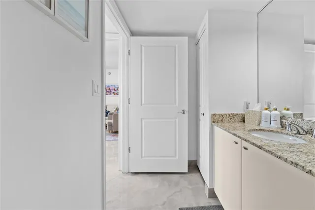 a bathroom with a granite countertop sink and a mirror