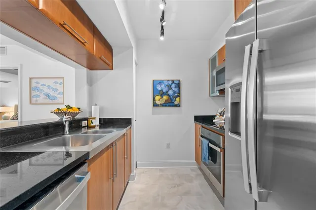 a kitchen with stainless steel appliances granite countertop a sink stove and refrigerator