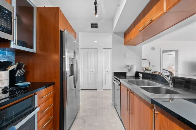 a kitchen with stainless steel appliances granite countertop a sink stove and refrigerator