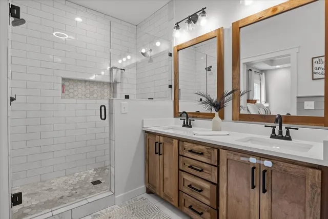 a bathroom with a double vanity sink mirror and shower