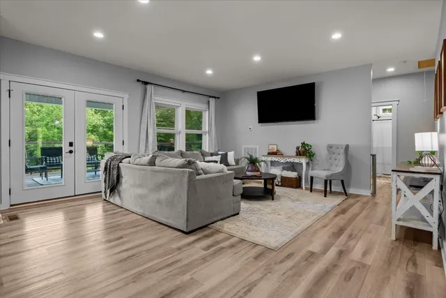 a living room with furniture flat screen tv and a large window