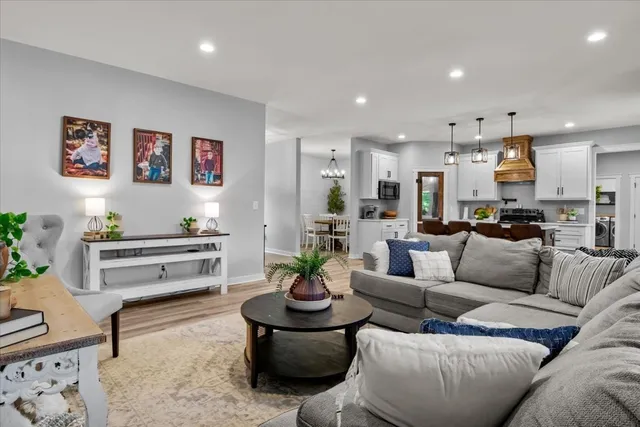a living room with furniture and a dining table with kitchen view