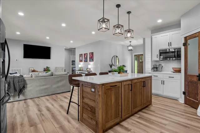 a large kitchen with kitchen island a island a stove a sink a center island and furniture