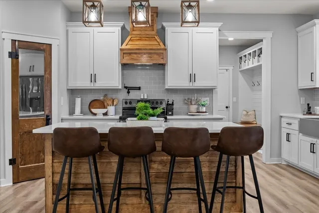 a kitchen with stainless steel appliances granite countertop a table chairs and a stove