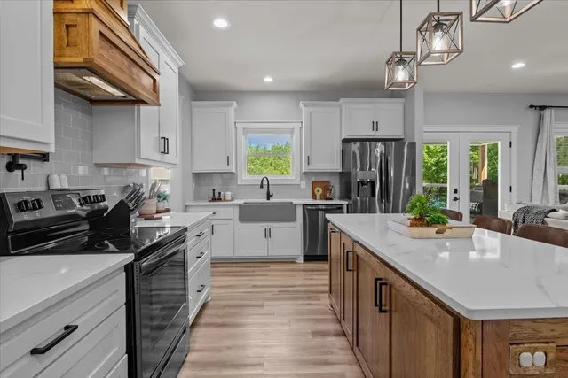 a kitchen with a sink stainless steel appliances a counter space and cabinets