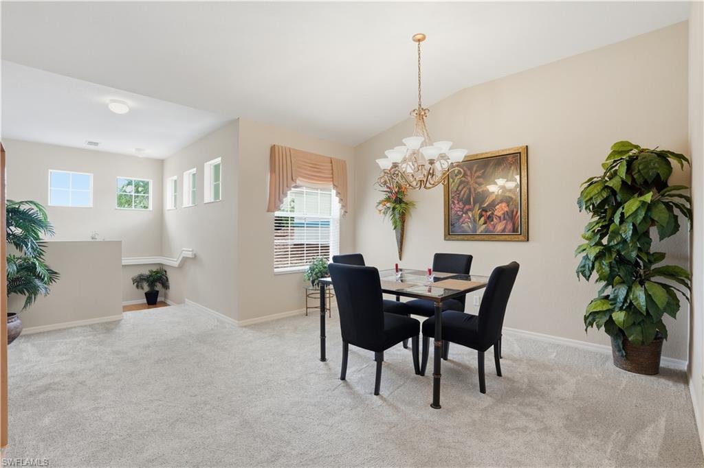 10871 Crooked River Road, Unit 202 Estero, FL 34135 - Photo 9 of 46 a view of a dining room with furniture and a chandelier