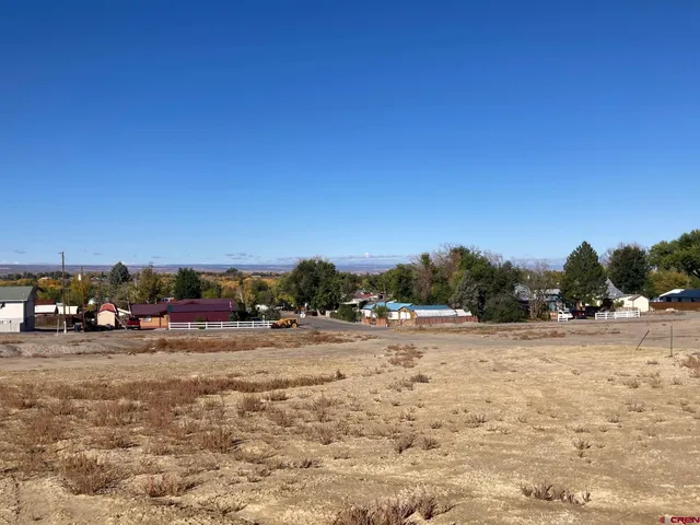 a view of dirt road with a building in the background