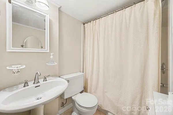 a bathroom with a sink toilet and mirror