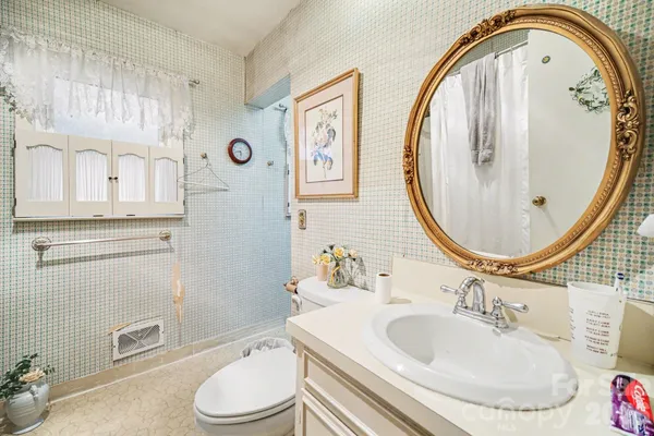a bathroom with a toilet a sink and a mirror