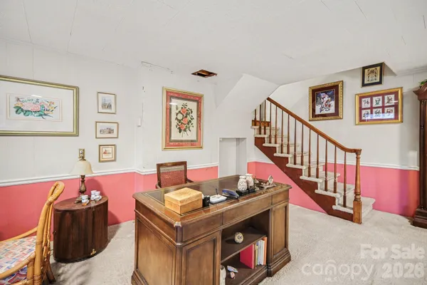 a living room with furniture and paintings on the wall