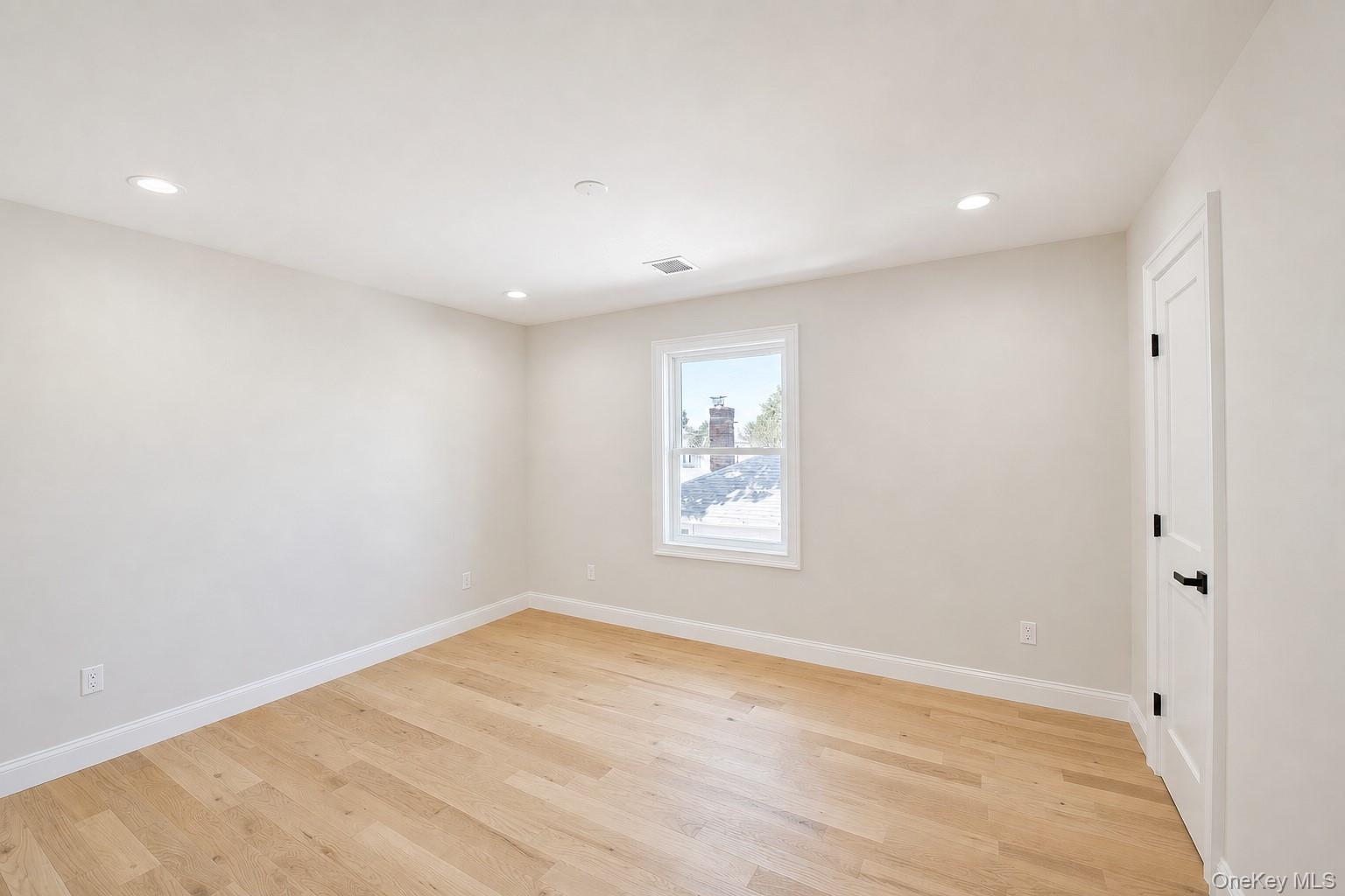 1316 R Street Elmont, NY 11003 - Photo 17 of 24 an empty room with wooden floor and window