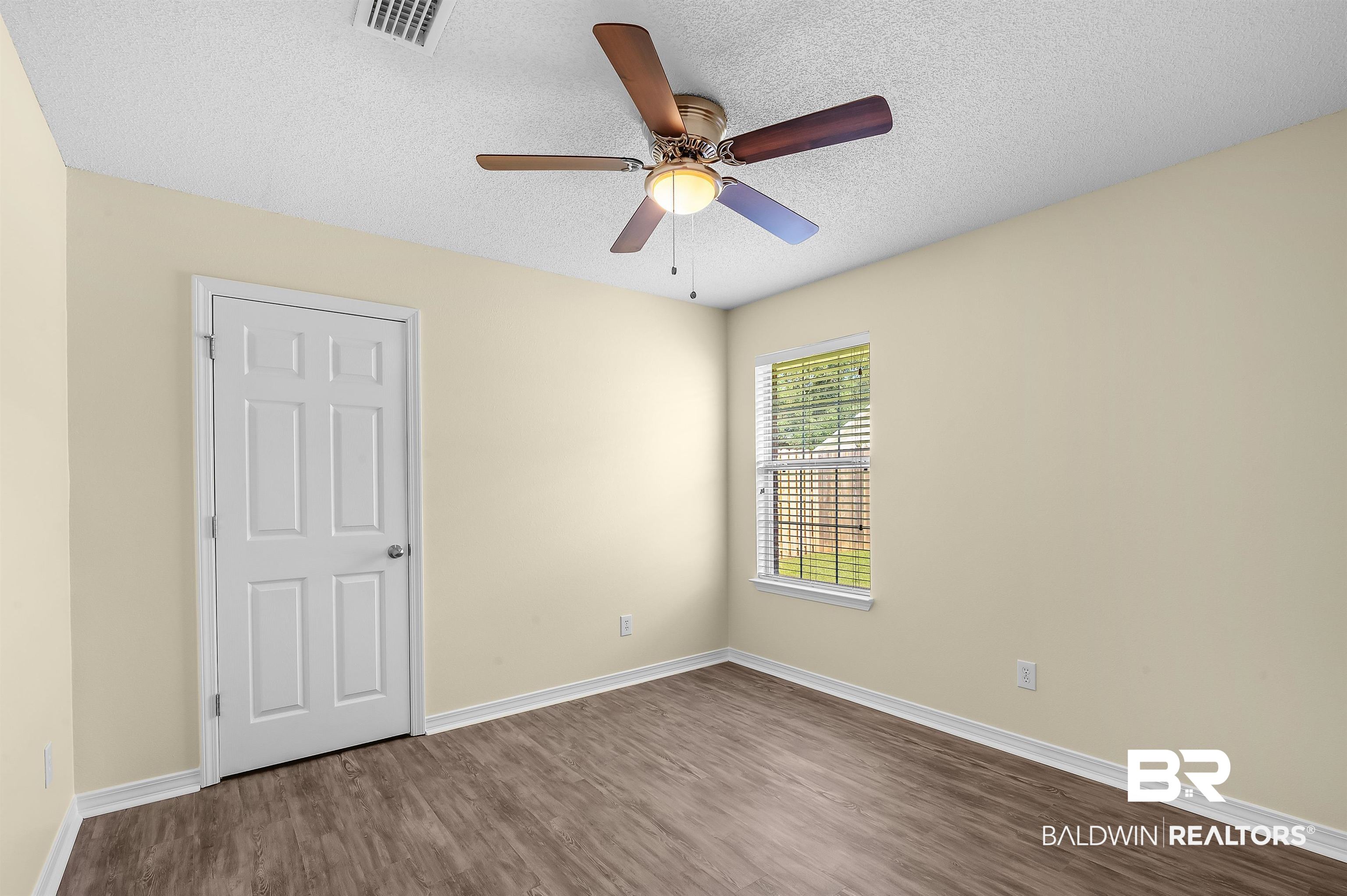 12443 Venice Boulevard Foley, AL 36535 - Photo 53 of 59 Unfurnished room with a textured ceiling, ceiling fan, and hardwood / wood-style flooring