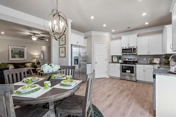 a open kitchen with stainless steel appliances granite countertop a stove refrigerator dining table and chairs
