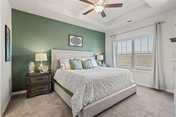 a bedroom with a bed chandelier and a window