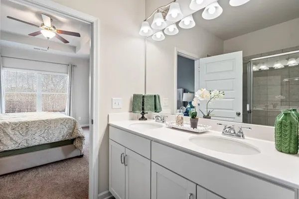 a en suite bathroom with a double vanity sink and a mirror