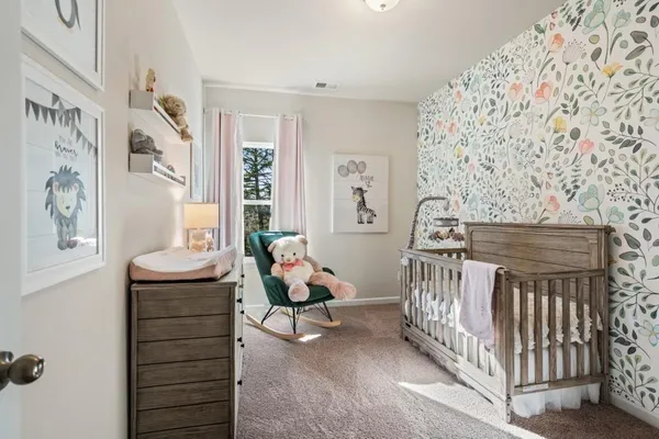 a bedroom with furniture and baby crib