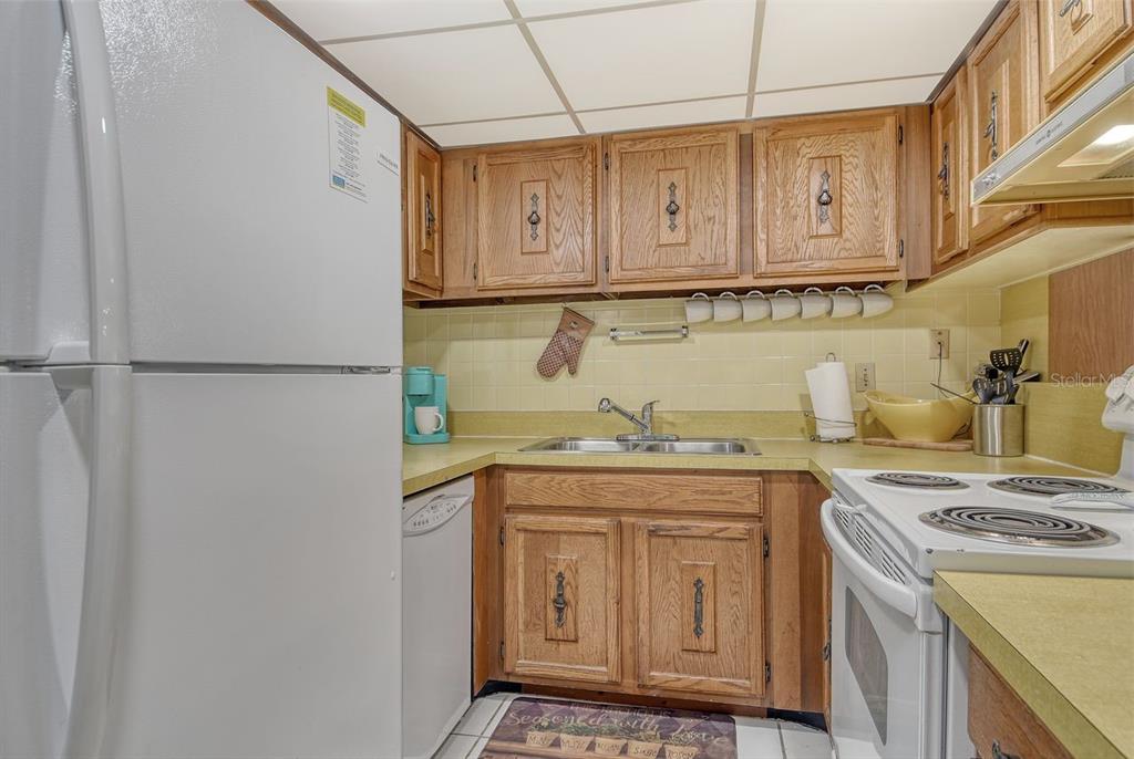 6157 Midnight Pass Road, Unit E63 Sarasota, FL 34242 - Photo 19 of 61 a kitchen with stainless steel appliances granite countertop a sink and a refrigerator