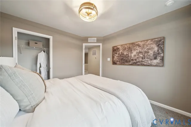 a bedroom with a bed and a painting on the wall