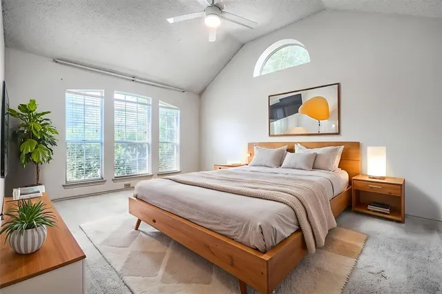 an empty room with windows and ceiling fan